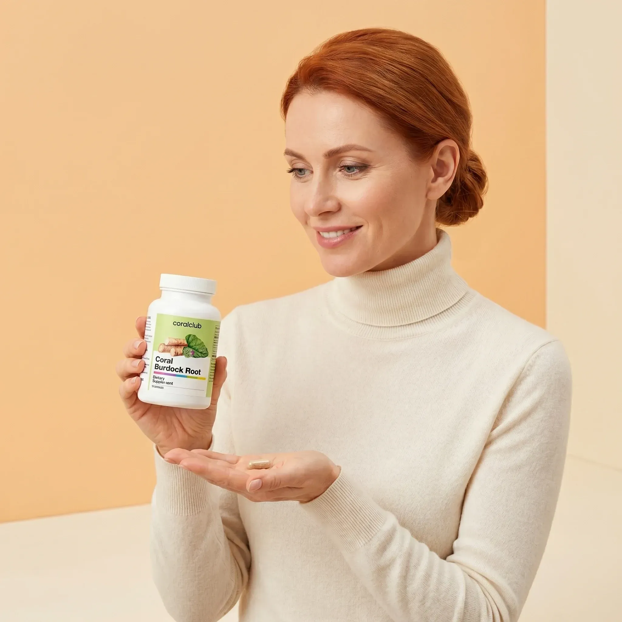 Woman holding Coral Burdock Root supplement bottle in a lifestyle setting, wearing a cream sweater.
