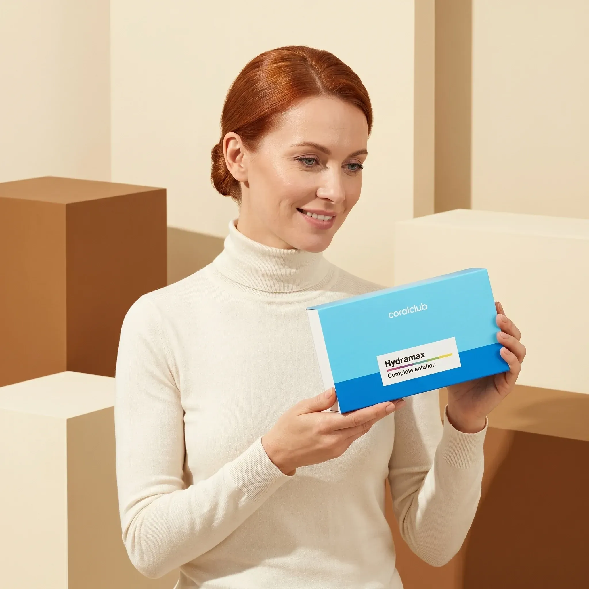 Woman holding HydraMax box in a minimalist lifestyle setting with neutral tones.