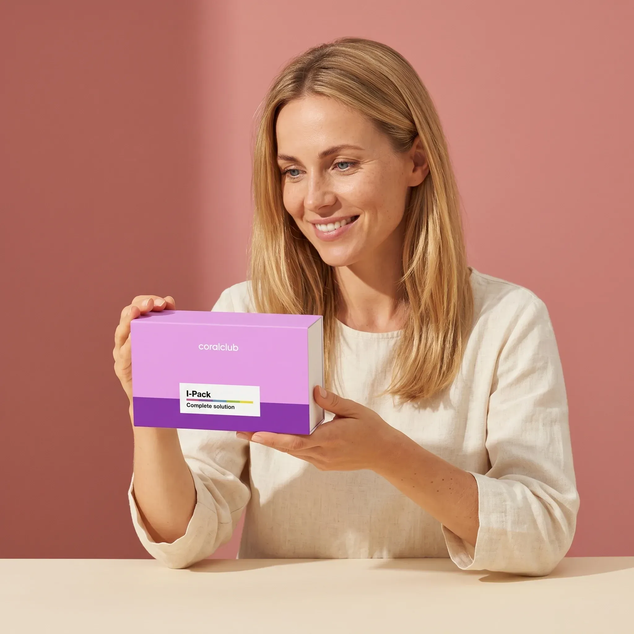 Woman holding Immunity Pack in a bright lifestyle setting with a pink background.